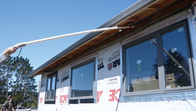 The insulation contractor used a long PVC wand — inserted to the end of the cavity and slowly withdrawn as material was blown in — to maintain a consistent density for the full length of the rafter cavities.