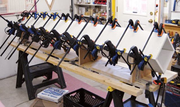 Though they are gluing a single corner, the authors have placed clamps on all four sides to keep things square.