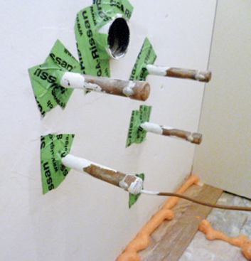 Small-diameter pipe penetrations through drywall or plywood are efficiently sealed with two short pieces of tape.
