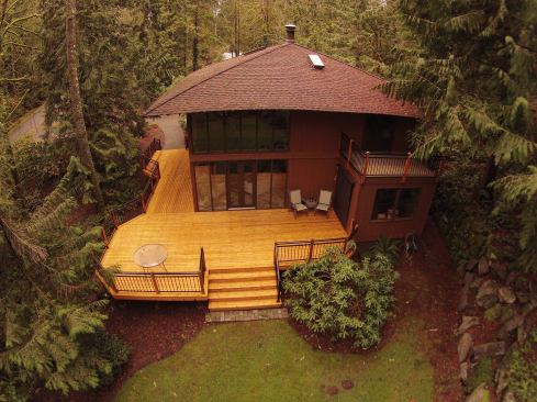 A tight knot cedar deck is a good match for the rustic setting of this home located near Issaquah, Washington. The tall trees surrounding the home shed a lot of pollen and organic matter, so the owner opted for a low-profile powder-coated aluminum railing with a view gap on top, which will just require periodic soap-and-water cleaning.