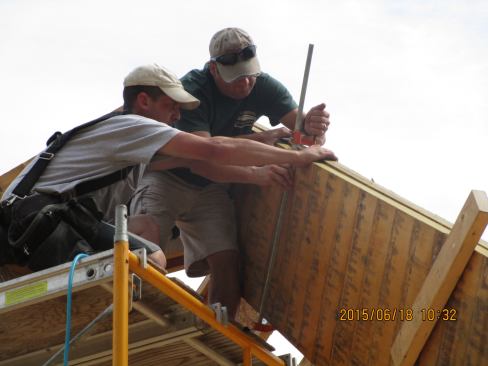 These very deep LVL timbers are not manufactured to fine tolerances. The two LVLs used to make this double hip rafter varied by more than a quarter inch. Here, framers use clamps to align the top edges of the two sticks.