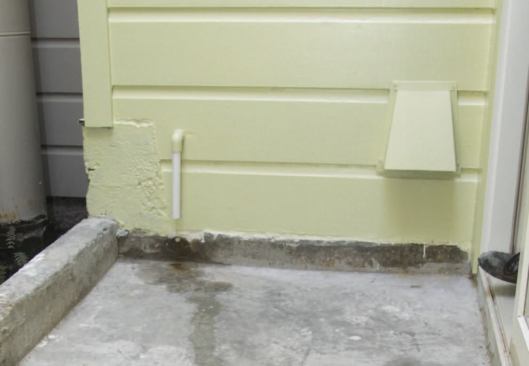 Further down the wall are the HRV exhaust hood and, to the left of the exhaust, a small pipe that serves as the outflow for the boiler condensate.