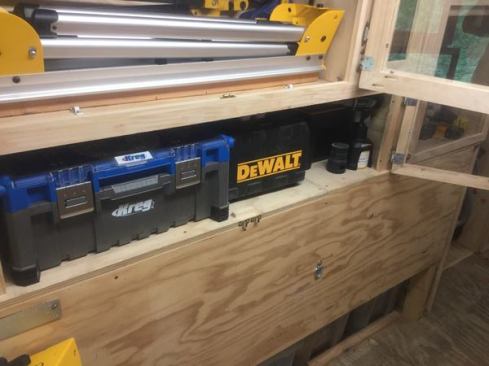 The Kreg Toolboxx and other tools live in the cabinet below the sawhorses. Note the ball catch fittings (to hold the doors closed) just below the shelf.