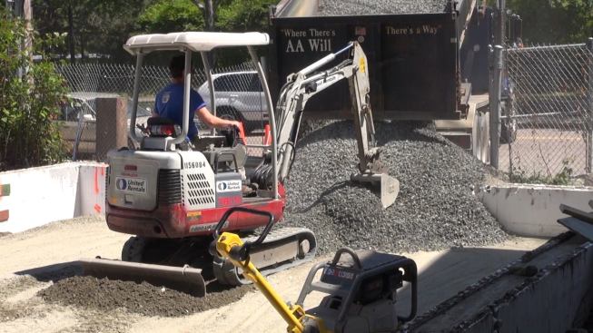 Evan Smith pulls a load of gravel into the foundation. The small skid-steer Smith is driving was the only piece of equipment that was practical for the small site, given the limited access from the street.