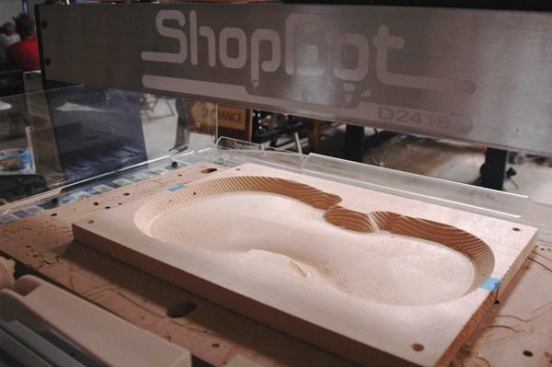 ShopBot’s stationary Desktop CNC machine is shown roughing out a violin back. When the board is flipped over, the machine will rout out the inverse of the profile, leaving a very thin curved piece of even thickness.