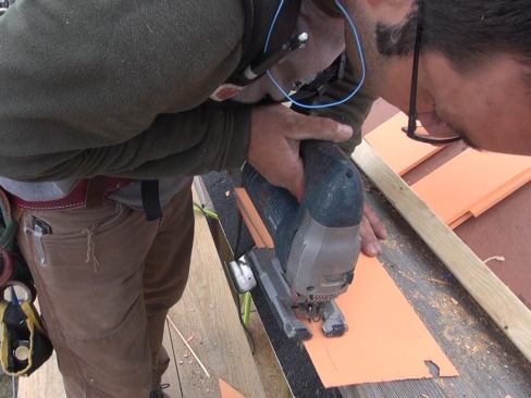 Pollard trims a shingle to his scribe line for a corner weave fit.