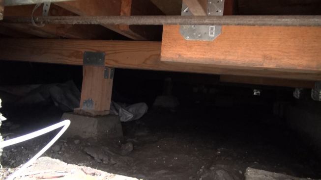 A view of the crawlspace beneath the dwelling, showing a little of the new structure Gregor and his crew created. The project included two new strip footings about two feet deep and two feet wide running across the width of the house to support shearwalls, as well as 32-inch-deep piers for new posts that ran up through the first story to support the second floor beam system and the roof.