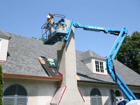 The stucco on the existing house was power-washed with a bleach solution, then a bonding agent was rolled on to the surface. We had to rent a boom lift for a few of the higher work areas.