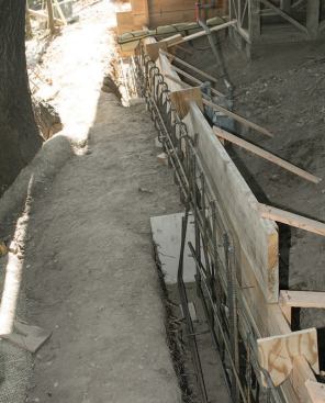 Where the roots of old oak trees grew under the house, the crew stopped trenching and instead formed engineered grade beams to connect the discontinued footings in those locations.