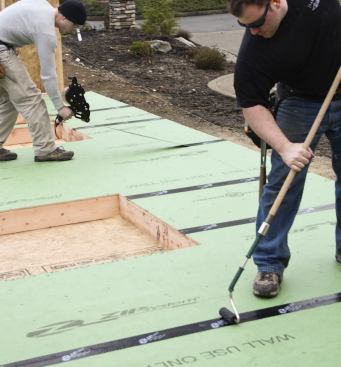 The tape gun has a built-in roller, but the crew also uses a J-roller to make sure the tape is firmly applied.