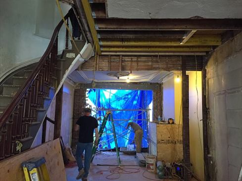 In the row homes we work on, the existing floor framing runs parallel to the front and back walls and is pocketed into the side party walls. At stair locations, the joists are mortise-and-tenoned into a header for the stair box-out. This header is usually undersized and ends up splitting along the pocketed mortises. To remedy this, we typically have to install a new LVL header and re-attach the existing joists with hangers.