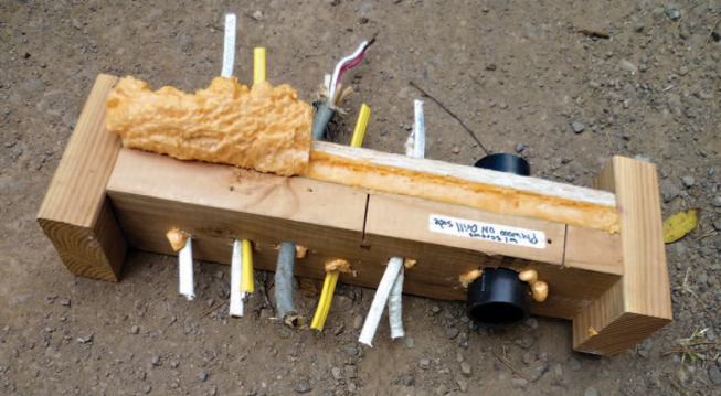 A scrap of pre-drilled plywood or OSB can be used to create an air-sealing “sandwich” where closely spaced pipes or wires penetrate wall framing at a plate.