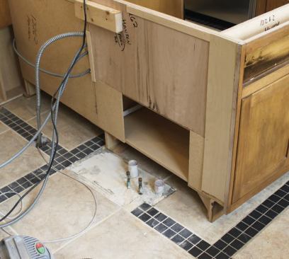 On removing the smaller cabinet, we were surprised to find waste and supply lines coming up through the floor where tile should have been.