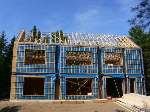 The completed structure before roof membrane and strapping. The trusses were set with a crane. In this view, you can see the diagonal 2x4 bracing for the truss system, and the metal spacers used to stiffen the top chords of the trusses.