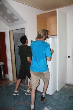 Final step: Pushing the existing kitchen refrigerator into place in the fridge enclosure.