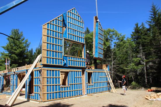 After framing the second floor deck (a five-panel assembly), the crew starts the second story walls at the gable end farthest from the crane. Gable end-panels were the heaviest panels in the modular package.
