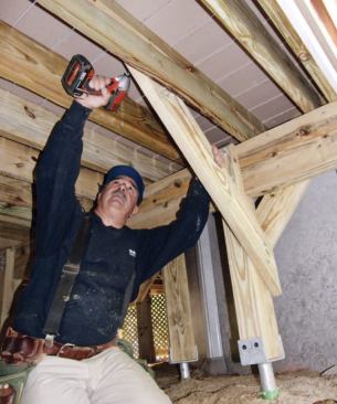 Lateral braces resist movement away from the house; these are installed from each post to the side of a joist.