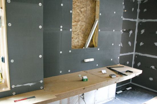 The half-inch-thick Wedi wall panels are installed with special washer-headed fasteners.