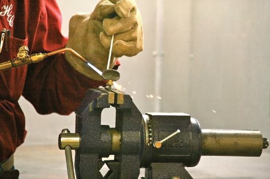 The author braze welds a new brass thumb screw to the existing steel bolt of his damaged miter gauge.