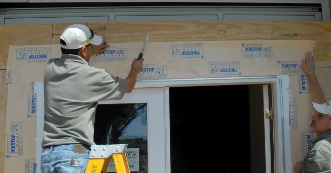The top flashing laps over the upper nailing flange and is installed after the door is in place.