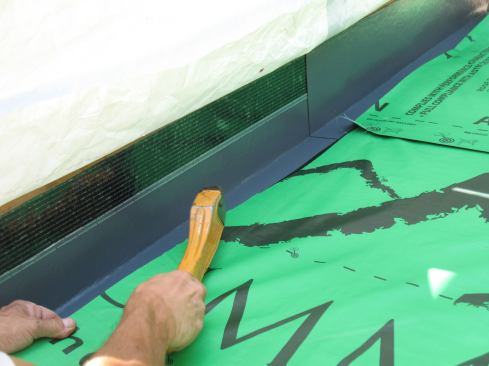 Mike tacks the joined pieces to the roof with staples.