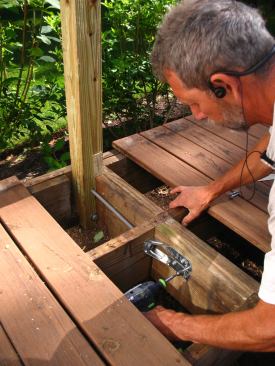 Along the sides of the deck, where the rim joist runs parallel to the deck joists, threaded rod is used to tie the guard posts to blocking installed between the joists.