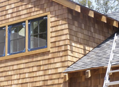 A 1-by board laid on the roof before shingling the wall above it creates a straight and consistent 3/4-inch gap between the siding and roofing after the board is removed.