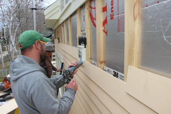 Fenton and Cunningham install the factory primed and first coated vertical grain red cedar clapboards. Field cuts are end-primed, then then bedded in polyurethane sealant where they contact trim elements.