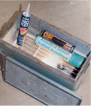 When the weather is cold, the author stores caulks and sealants in an old metal cooler heated by a light bulb. A rack keeps the tubes off the bulb.