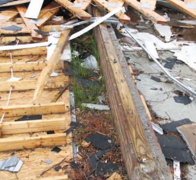 A closer look at the left-hand garage wall shows that the OSB sheathing was poorly attached to the bottom plate with 8-penny nails 16 inches on-center. Foundation anchor bolts with round washers were spaced 48 inches on-center along the sill plate.