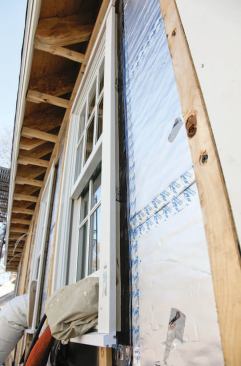 Water that bypasses the siding and trim is shed by the foam sheathing's foil face.