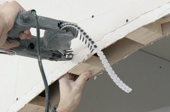 Scraps of 2x4 blocking are screwed to the drywall act as backing.