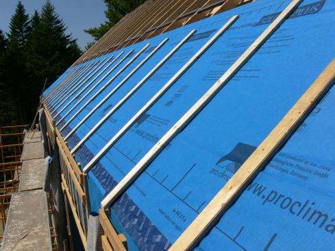 This view shows the first vertical strapping pieces applied to the roof truss top chords through the Solitex Mento membrane.