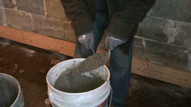 Martignetti works the stiff mortar on the trowel.