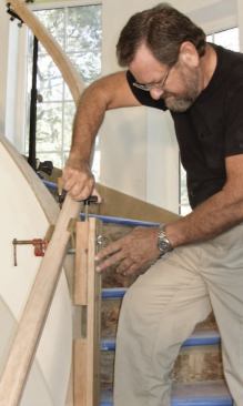Height adjustments are made with a 1/4-inch threaded rod and a T-nut. The 20-inch length of threaded rod passes through a hole bored lengthwise in the upper 2x4, through the T-nut, and several inches into the lower 2x4, where it bottoms out on a 1/4-inch ball bearing. Turning the handle epoxied to the top moves the upper 2x4 up or down.