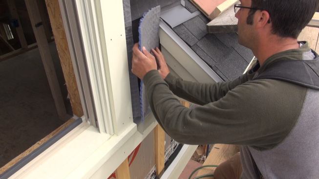 Pollard fits a small scrap of Mortairvent into place on the front wall of the dormer.
