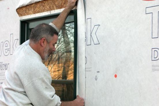 Flash the Jambs and Head
Starting 2 to 3 inches above the window head, I apply flashing membrane over the jamb flanges, letting the tape extend at least to the bottom of the sill flashing.