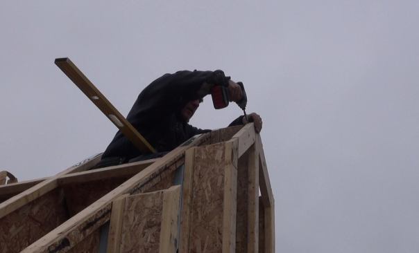 Screwing the roof peak blocking into place.