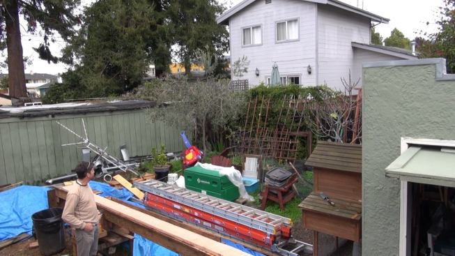 A view of the back lot behind the bungalow, cluttered now because of the construction. Gregor opted to preserve the outdoor living space behind the house. In California’s mild Mediterranean climate, fenced and landscaped outdoor spaces commonly serve as another room in the dwelling.