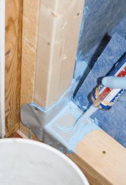 After slitting the perimeter membrane to allow it to fold over the jamb, I squirted sealant onto the preformed corners.