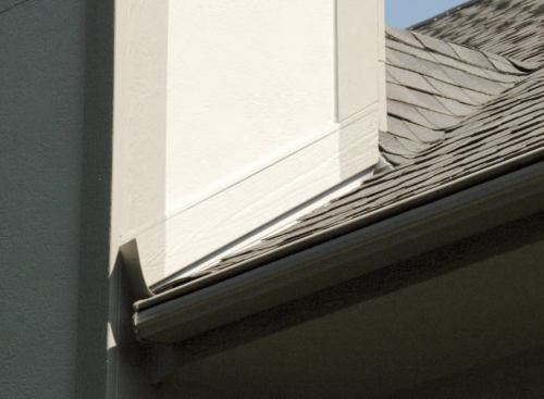 I don't like the look of too much exposed step flashing, so we covered the steps with MiraTec trim installed at the pitch of the roof, maintaining an inch of clearance between the trim and the shingles.