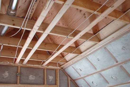 Unused attic spaces are part of the home's conditioned space, so the rafters are insulated up to the ridge. Note that plywood is used in the attic to hold the insulation in place where there is no drywall.