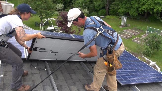 Bernard and Janarelli lower a module onto the mounting rail.