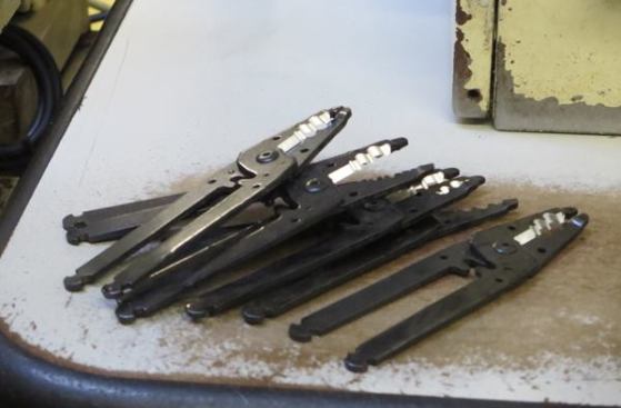 Wire strippers machined, assembled, and ready for handles. 
Click here to see video of over-molded grips being applied.