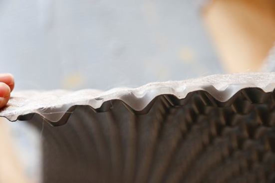 You can see the plastic dimple has a fabric adhered to one side. The plastic nipples go against your WRB (weather resistive barrier) and the fabric faces out.