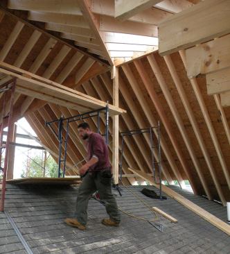 Two structural valley timbers and two structural ridge timbers converge at this central point in the roof, supported at the apex by a single post that penetrates the roof and extends down to a bearing point on the existing wall below. “Whenever I put an addition onto existing, I start with existing structural points that I want to hit,” says Andy DiGiammo.