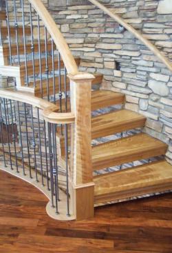 The lower treads of the completed stair seem to grow out of the stone.