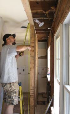 We started by removing cabinets and appliances, then cut back a 2-foot width of ceiling drywall so that we could build a temporary studwall to support the second-floor framing over the kitchen.