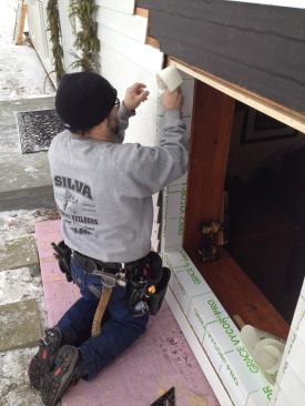 A second piece of flashing tape finishes the sides of the opening with the cut leg extending up and under the existing tar paper underlayment.