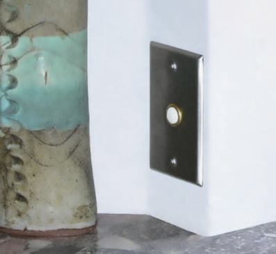 A hard-wired push-button switch is installed next to a kitchen sink.